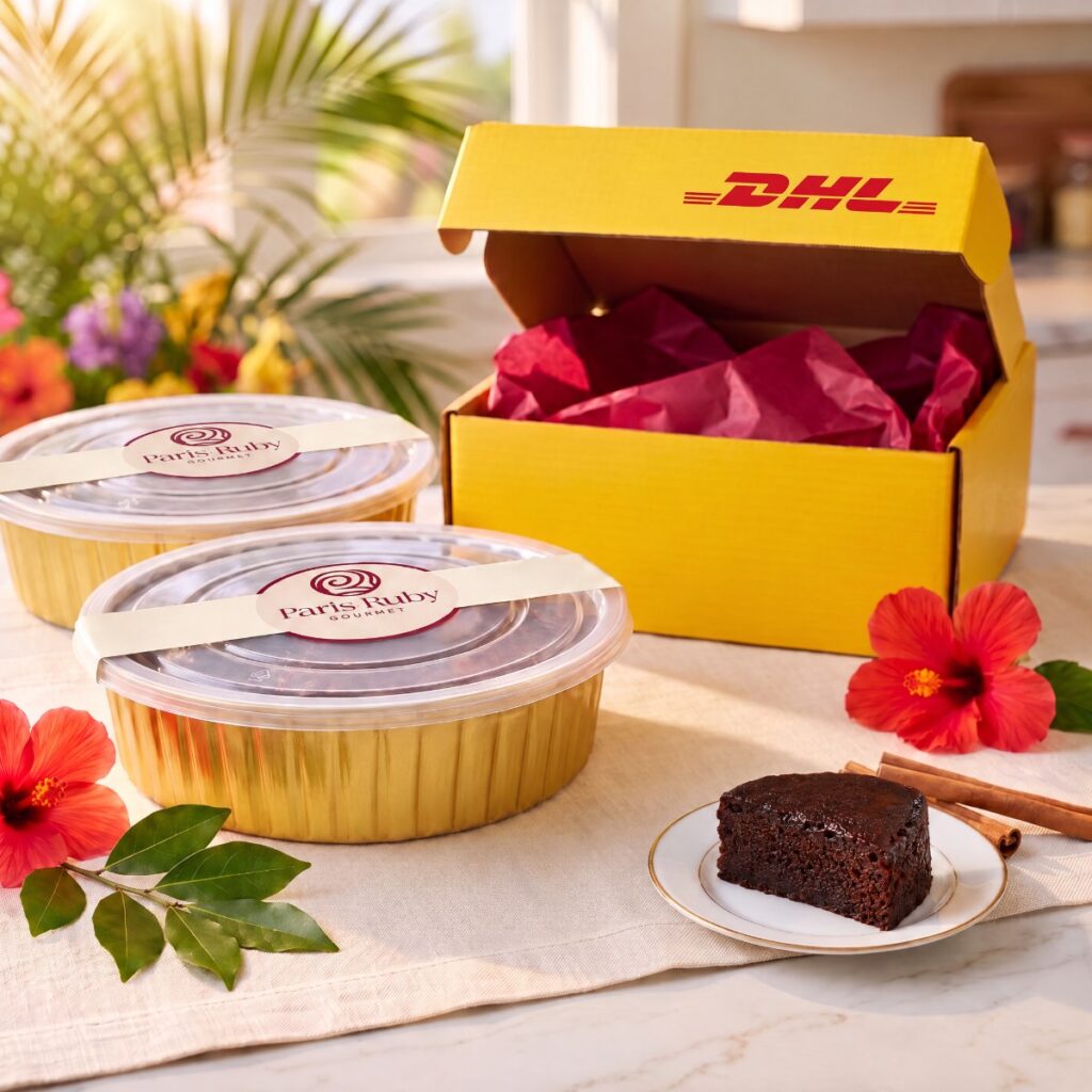 Two 1 lb Paris Ruby fruitcakes in gold pans beside an open yellow DHL Express box