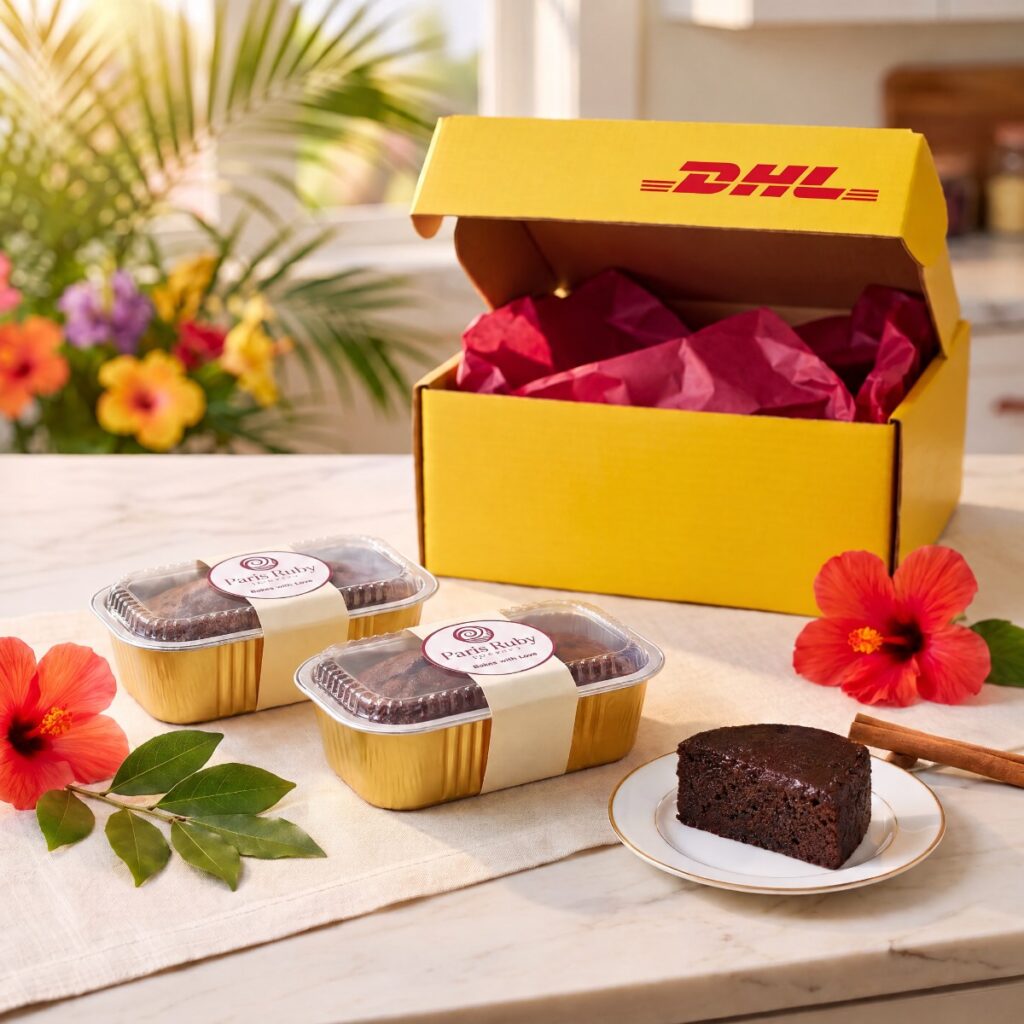Two half-pound Paris Ruby mini fruitcakes in gold pans beside an open yellow DHL Express box
