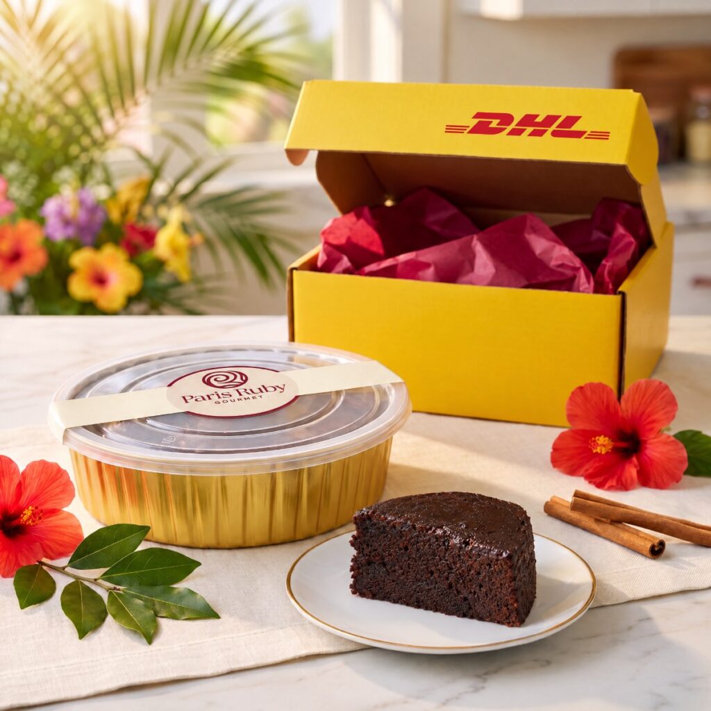 One 1 lb Paris Ruby fruitcake in a gold pan beside an open yellow DHL Express box